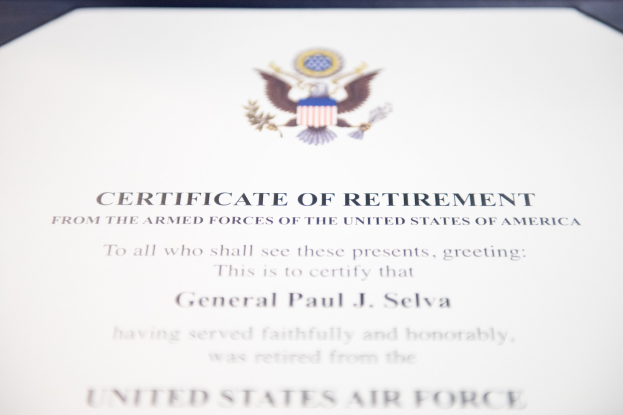 Rahmenurkunde für den Ruhestand der United States Air Force mit blauem Rand, die ein zentrales Sternsymbol innerhalb eines Lorbeerkranzes und eine "Ruhestand"-Bannerschrift in schwarzer Tinte zeigt.