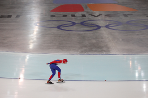 Eine Person in einem roten und blauen Kleid fährt auf einer weißen Fläche mit Text auf einem grauen Hintergrund.