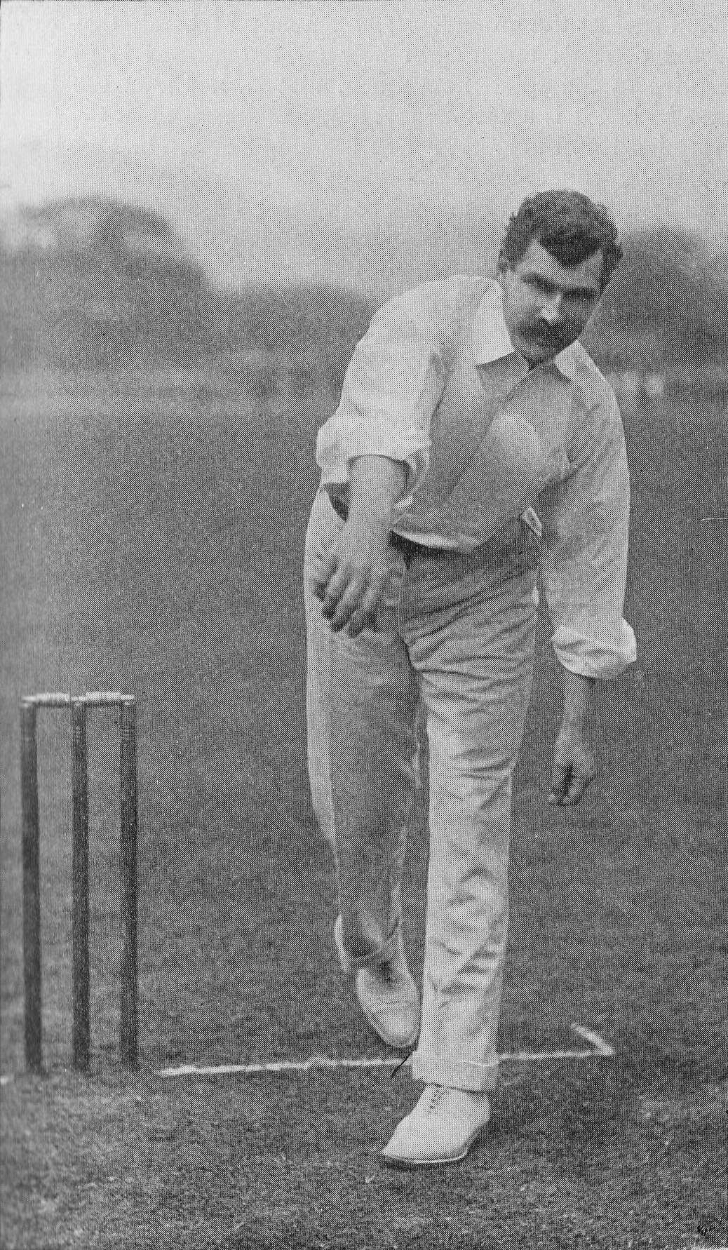 Ein Mann in weißem Hemd und Hose spielt Cricket mit Wickets auf dem Boden, Bäumen und Himmel im Hintergrund, mit "Cricket Player of the Year"-Text unten.