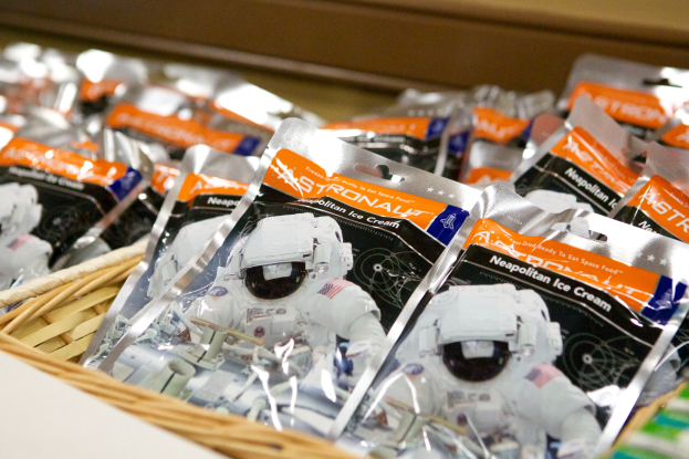 Ein Korb voller Eiscreme-Packungen auf einem Tisch, mit einem Spielzeug im Vordergrund und einem unscharfen Hintergrund.