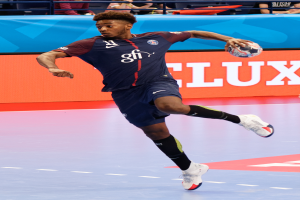 Ein Mann in einer blauen Uniform, identifiziert als Paris Saint-Germain, spielt Handball in einem Stadion während der Futsal-Weltmeisterschaft 2019, mit Zuschauern im Hintergrund.