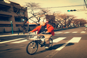 Ein Mann fährt mit dem Fahrrad auf einer Straße vorbei an einer Ampel.