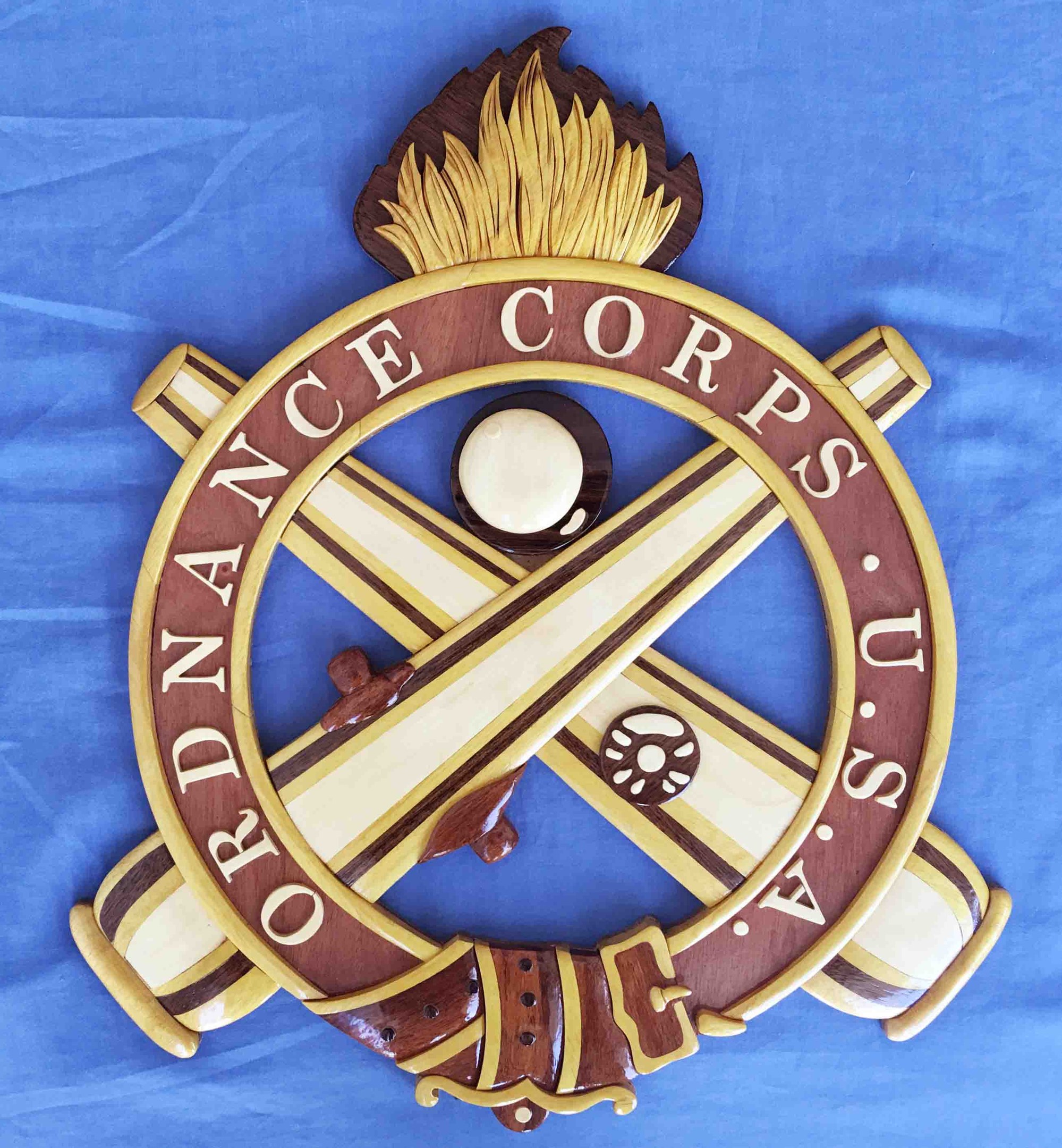 Holzschild mit "Ordnance Corps"-Text, das eine geschnitzte weiße Stern auf einem marineblauen Hintergrund mit einer goldenen Umrandung zeigt, auf blauem Tuch montiert.
