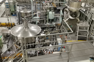 Ein großes Reaktorgerät in einem Gebäude mit einem Boden, Geländern, Treppen und diversen umliegenden Komponenten und Maschinen.