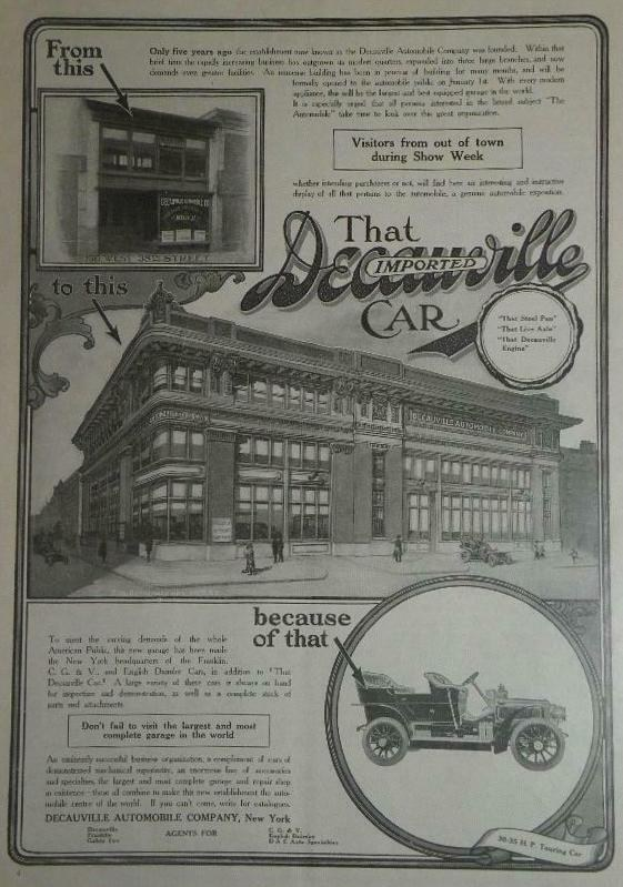 Klassisches Auto der Decaville Automobile Company vor einem zweistöckigen Gebäude unter einem strahlend blauen Himmel geparkt.