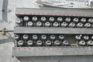 Nahaufnahme eines Stromzählers an der Seite eines Gebäudes mit einer Banneranzeige oben