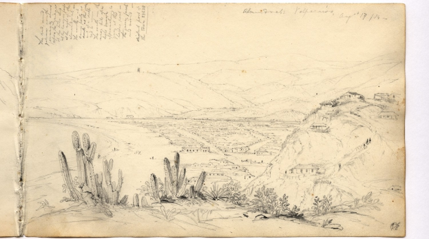 Ein aufgeschlagenes Buch, das eine Zeichnung einer Wüstenlandschaft mit Hügeln, Pflanzen und Text zeigt.