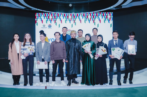 Gruppe von Menschen auf einer Bühne mit Blumen und Urkunden, vor einem "Youth Solar Awards 2019"-Plakat.