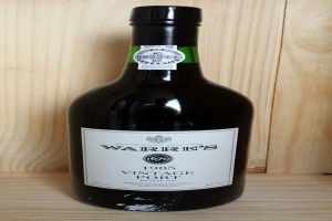 Ein Bierflasche mit Etiketten liegt auf einem Holzweg.