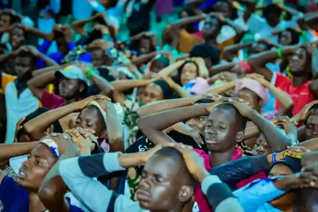 Eine große Gruppe von Menschen, die zusammen sitzen und fröhlich feiern vor einem unscharfen Hintergrund.