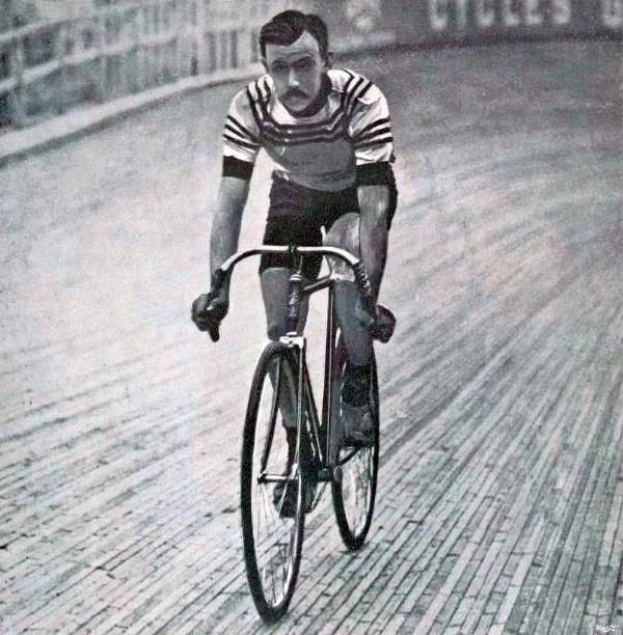 Schwarz-weißes Foto eines Mannes, der auf einer Bahn ein Fahrrad fährt.