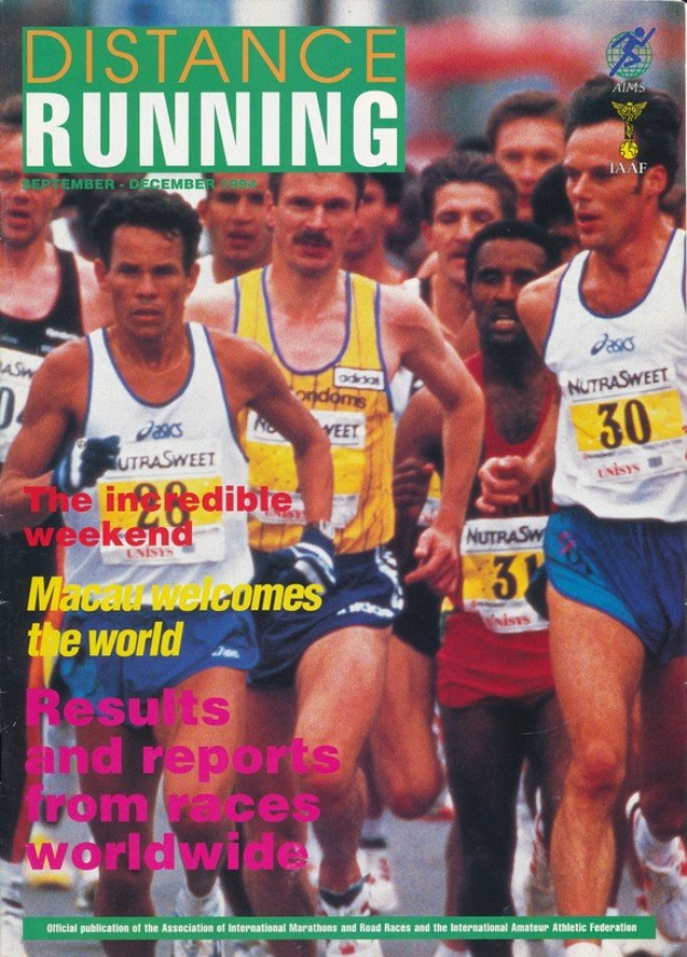 Ein Magazin-Cover mit der Aufschrift "Langstreckenlauf", das eine Gruppe von Menschen zeigt, die bei einem Marathon laufen, wobei einige bunte Laufschuhe und andere Shorts und T-Shirts tragen, vor einem hellblauen Himmel mit weißen Wolken.