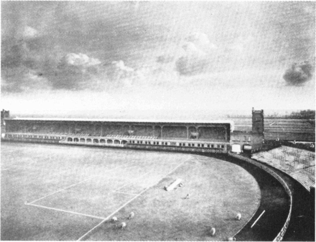 Schwarzes und weißes Foto eines Fußballfeldes mit einem Stadion im Hintergrund, umgeben von Bäumen und einem bewölkten Himmel, beschriftet mit "Stoke City Football Club" unten.