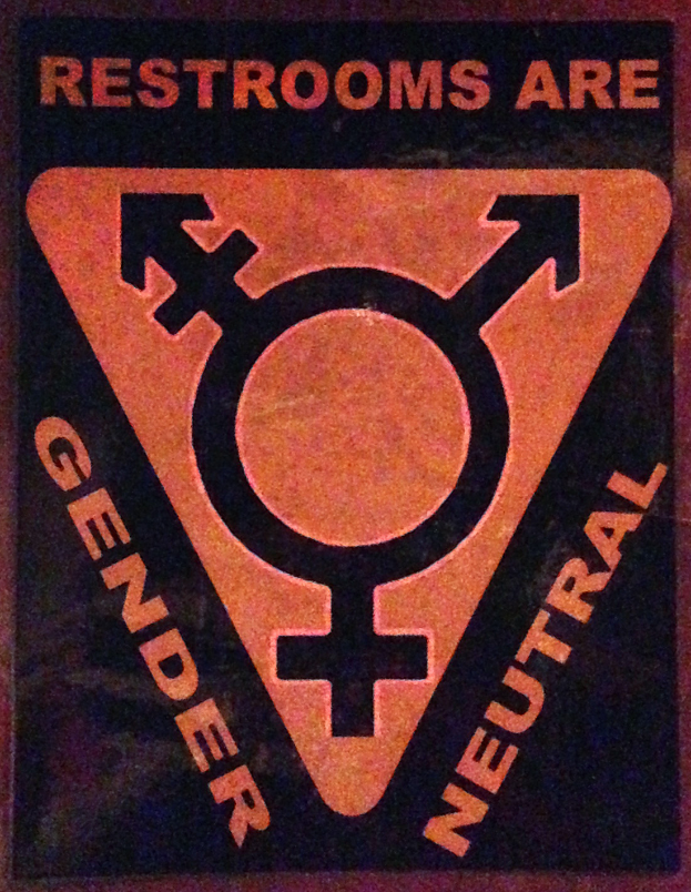 Ein Plakat mit der Aufschrift 'Toiletten sind geschlechtsneutral' betont die Bedeutung des Geschlechts in Toiletten.