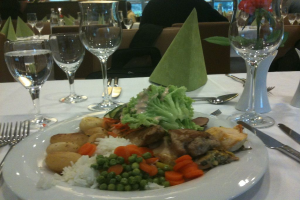 Ein Teller mit Essen und Weingläsern auf einem Tisch.