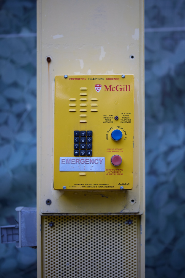 Gelber Notrufknopf an einer Gebäudewand montiert, für Notrufe entworfen.