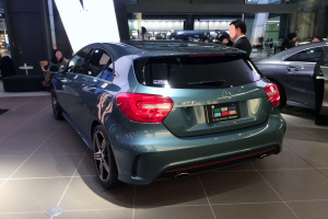 Ein Mercedes-Benz A-Klasse Schrägheck auf der IAA in Frankfurt, ein schlankes, modernes Design mit glänzender schwarzer Lackierung und Chromakzenten, umgeben von einer Gruppe von Menschen.