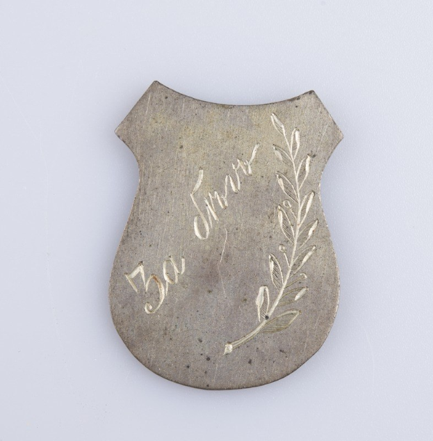 Silbernes Abzeichen mit Lorbeerkranz-Design, beschriftet mit "50. Hochzeitstag", auf einem weißen Hintergrund.