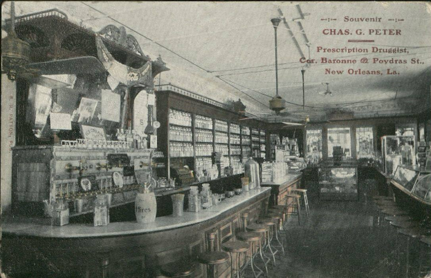 Altes Schwarz-Weiß-Foto eines Apothekeninneren in New Orleans, Louisiana, mit Hockern, Tischen mit Flaschen, Glasfenstern auf der rechten Seite und Text oben.