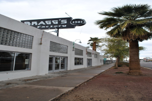 Ein Gebäude mit einer Flagge, auf der 'Braggs Factory' steht, umgeben von Bäumen.